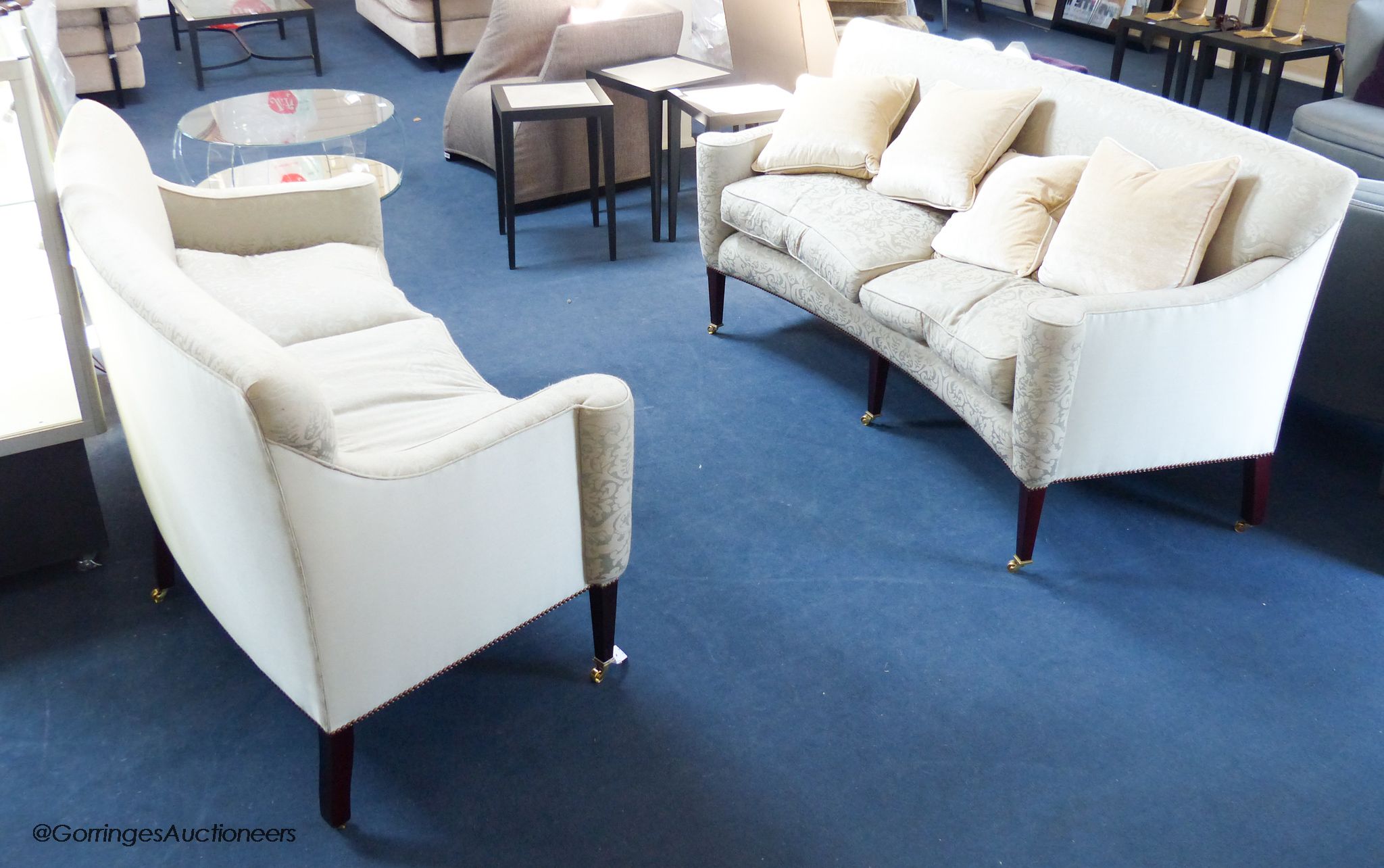 A pair of George III style eau de nil silk damask concave fronted two seat sofas, on square tapered mahogany legs with brass casters, approximately 188 cm wide